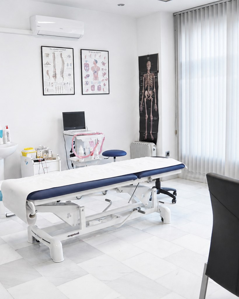 Sala de consulta de la clínica de fisioterapia Saavedra en Almería, con camilla de tratamiento y material anatómico