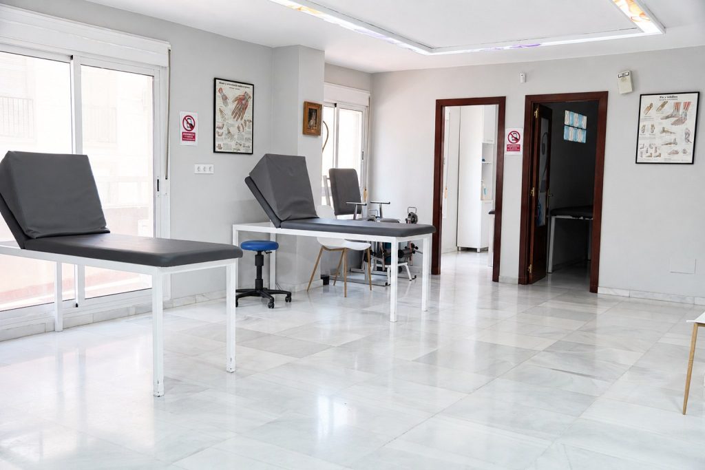 Sala de tratamiento con dos camillas y luz natural en la Clínica Saavedra de Roquetas de Mar